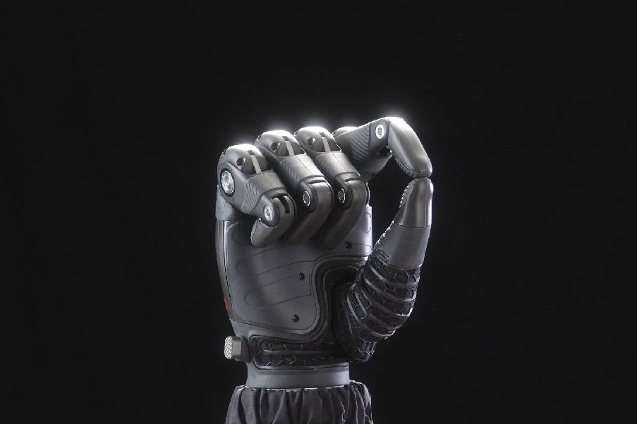 A dramatically lit TASKA prosthetic hand performing a pincer grip.